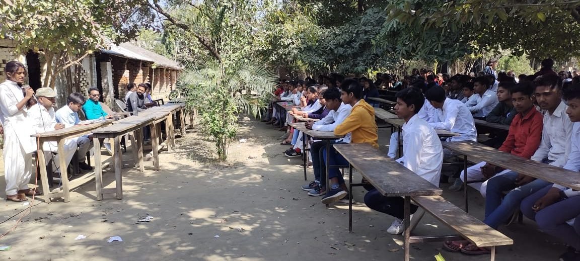 Children seated at benches for an open-air class